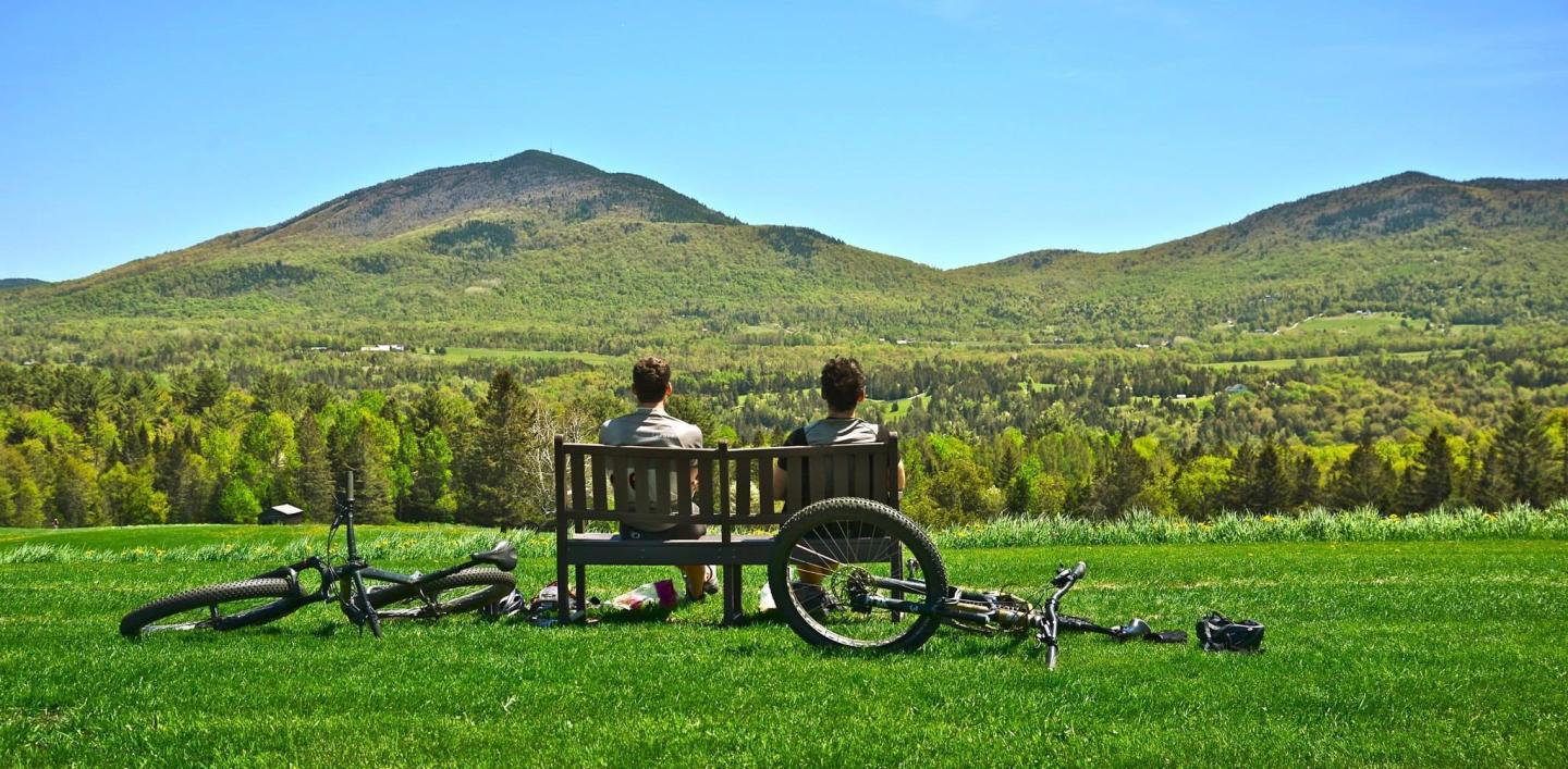 Two people sitting on a bench in a park