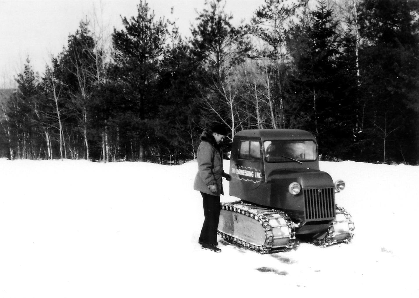 An old black and white photo of a person with a snow cat