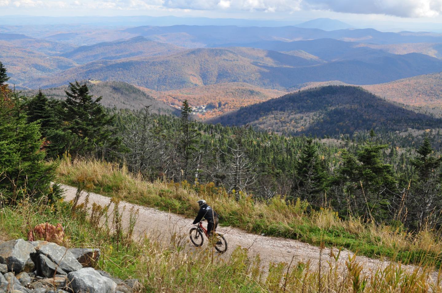 A person biking on a trail in the mountains